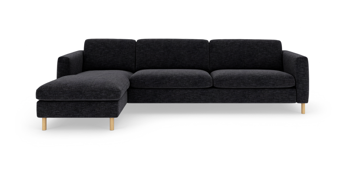Mørkegrå sofa med venstrevendt chaiselong, stofbetræk og lyse træben, frilagt på hvid baggrund.