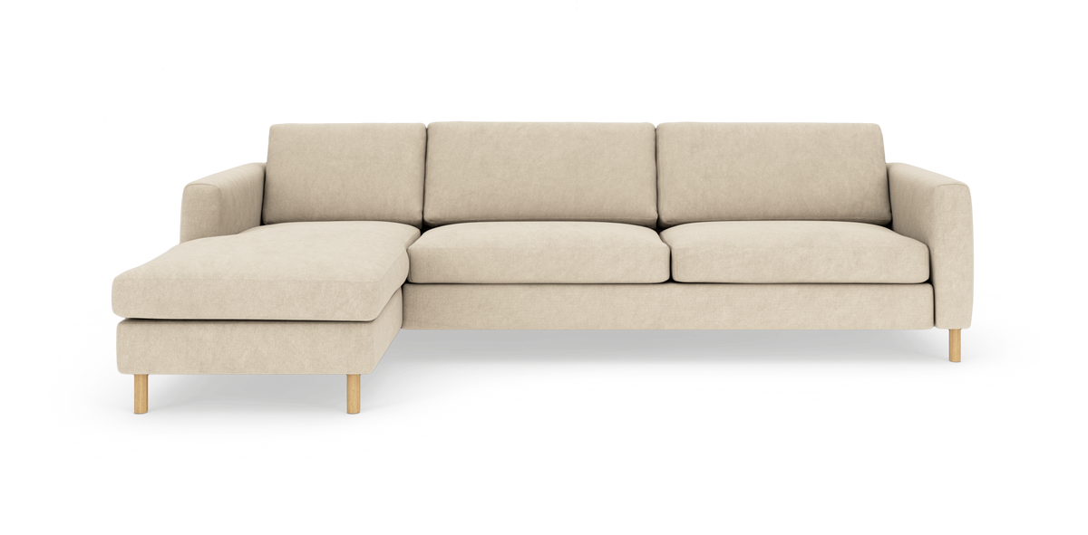 Beige hjørnesofa med venstre chaiselong, rene linjer og træben, fritlagt på hvid baggrund.