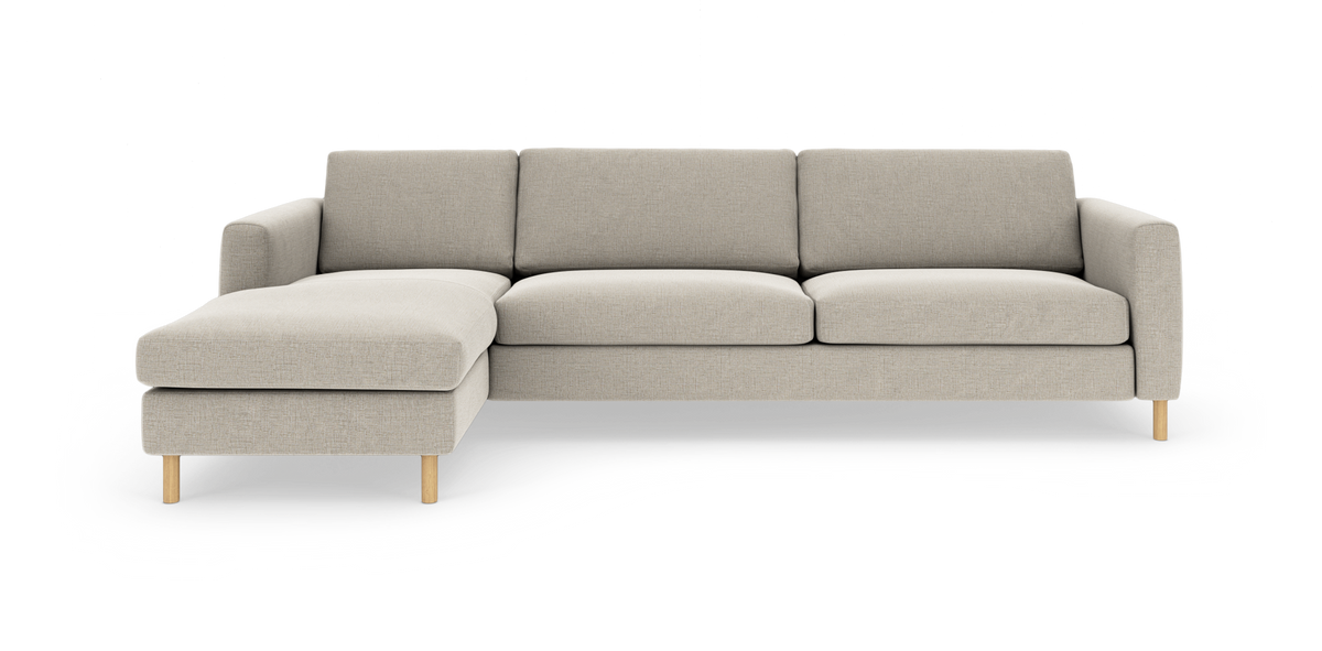 Beige sofa med venstrevendt chaiselong og runde træben, set forfra på studiehvid baggrund.