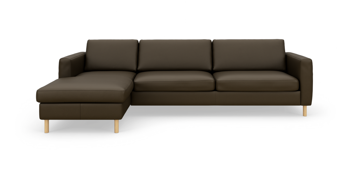 Mørkebrun hjørnesofa med venstrevendt chaiselong og lyse træben, fotograferet lige for i studie.