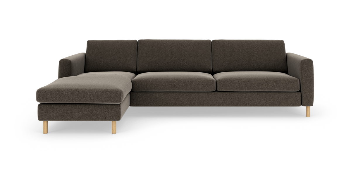 Moderne modulsofa med venstrevendt chaiselong i mørk brun tekstil og lyse træben, set forfra på hvid baggrund.
