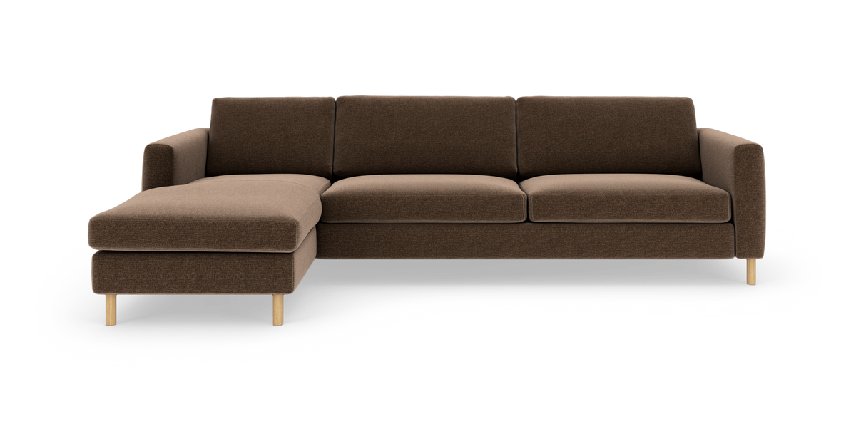 Brun modulsofa med venstrevendt chaiselong, træben og lige armlæn, frilagt på hvid baggrund.