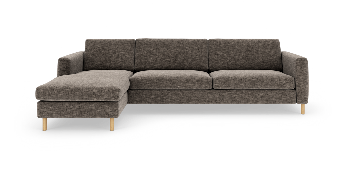 Venstrevendt hjørnesofa i mørkegråt stof med chaiselong og lyse træben, fritlagt på hvid baggrund.