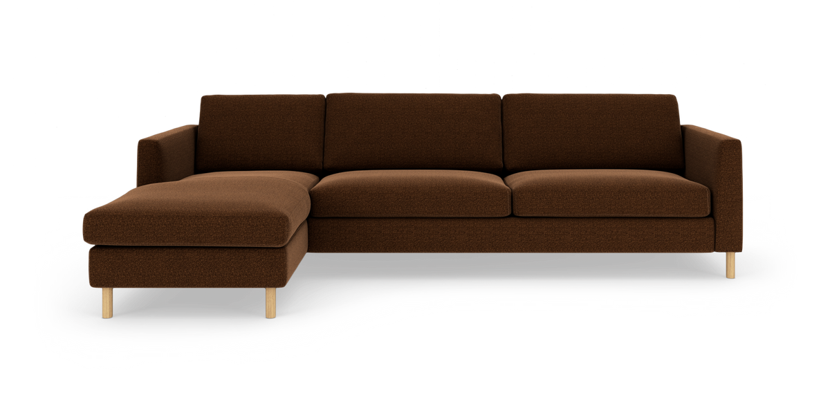 Brun L‑sofa med venstrevendt chaiselong, tre sædehynder og lyse træben, frilagt på hvid baggrund.