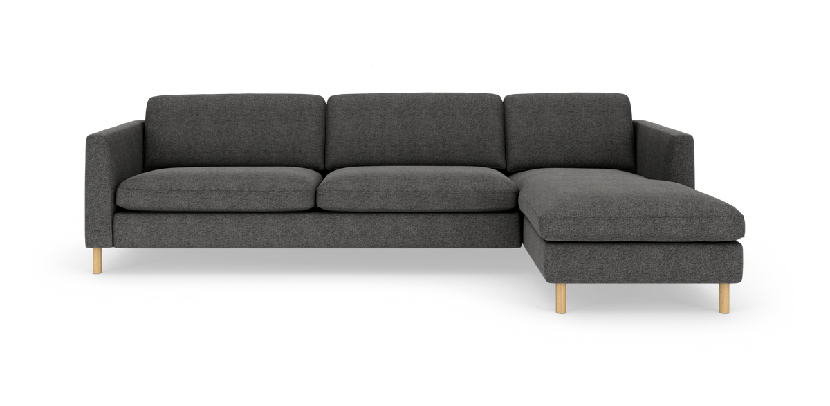 Mørkegrå modulsofa med højrevendt chaiselong på lyse træben, frilagt mod hvid baggrund.
