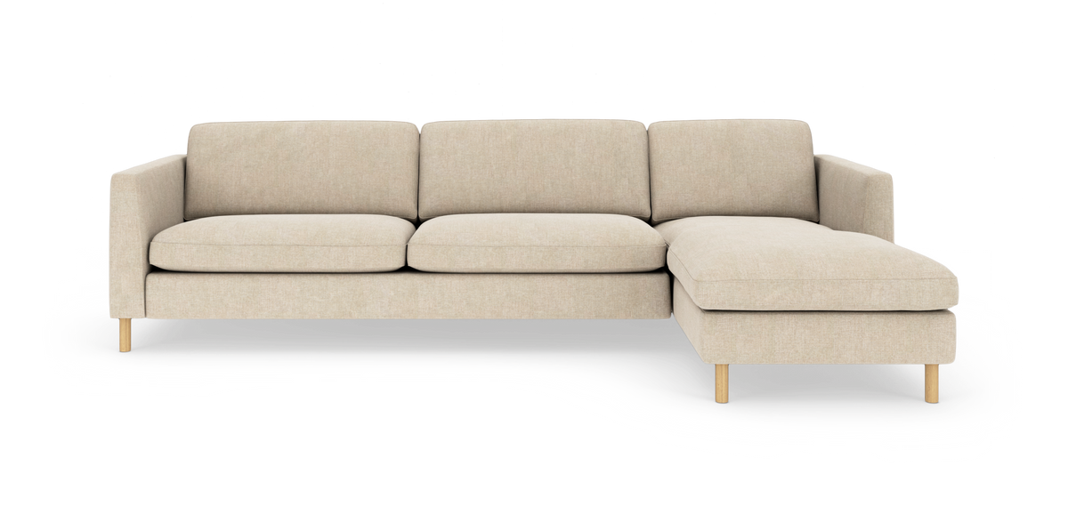 Beige hjørnesofa med chaiselong til højre på lys baggrund.
