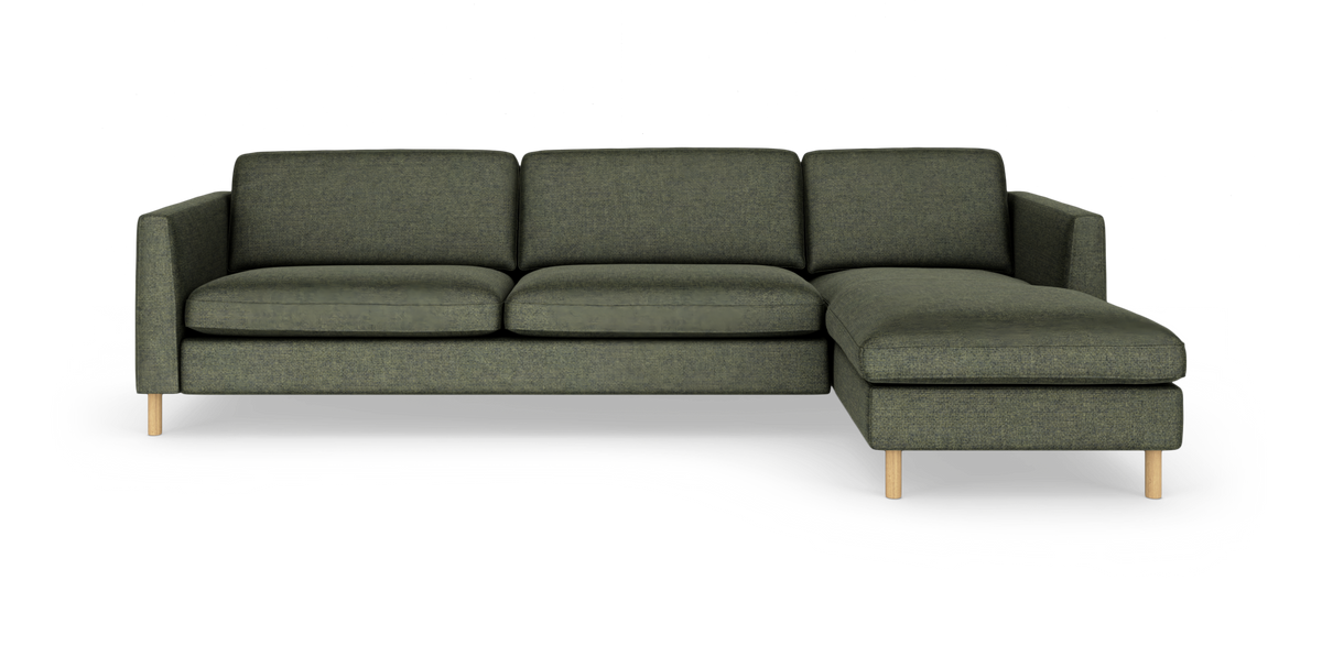 Grøn modulsofa med højrevendt chaiselong på slanke træben, frilagt på hvid baggrund.