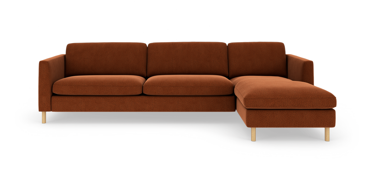 Rustfarvet modulsofa med højre chaiselong, slanke træben og rene, moderne linjer på hvid baggrund.