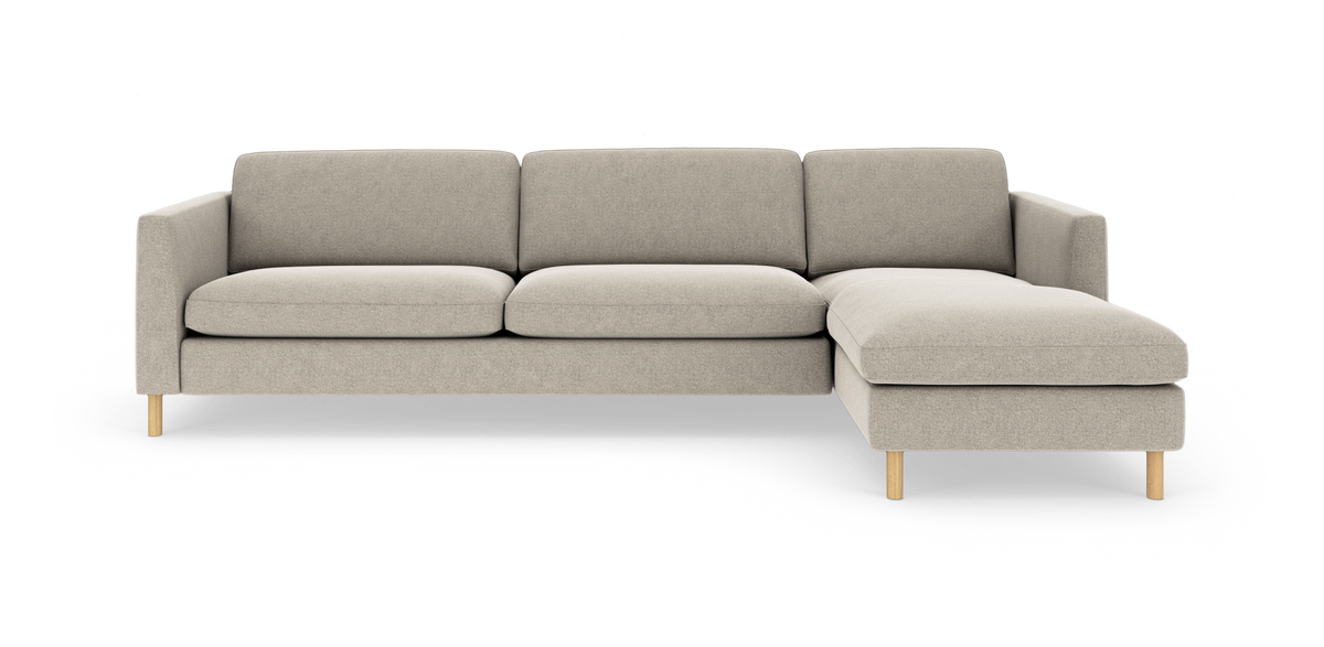 Lysebeige hjørnesofa med chaiselong til højre på træben, frilagt mod hvid baggrund.