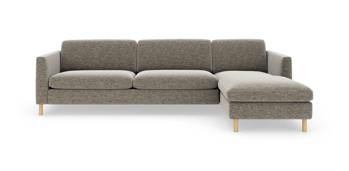 Modulsofa med højre chaiselong i gråbeige stof og lyse træben, frilagt på hvid baggrund.