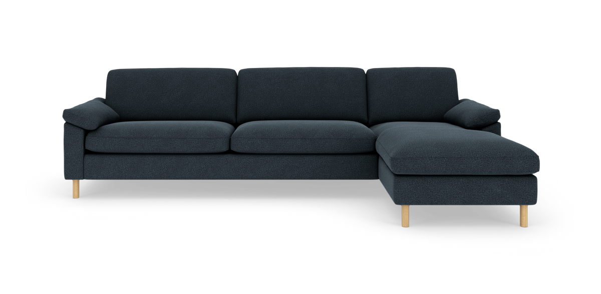 Mørkeblå hjørnesofa med chaiselong til højre og træben, fritstående på hvid baggrund.