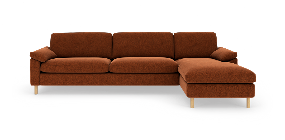 Brun hjørnesofa med chaiselong til højre og lyse træben, fritlagt på hvid baggrund.