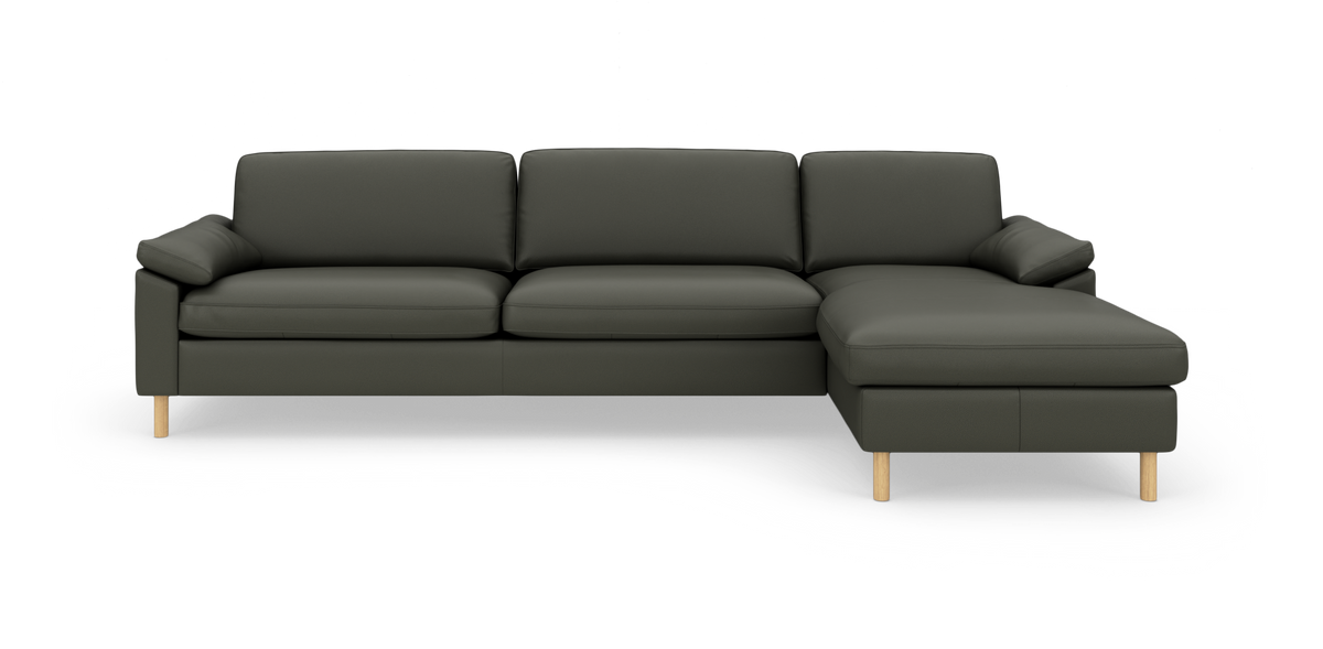 Mørkegrå/grøn L-formet sofa med højrevendt chaiselong og slanke træben, frontvisning i studie.