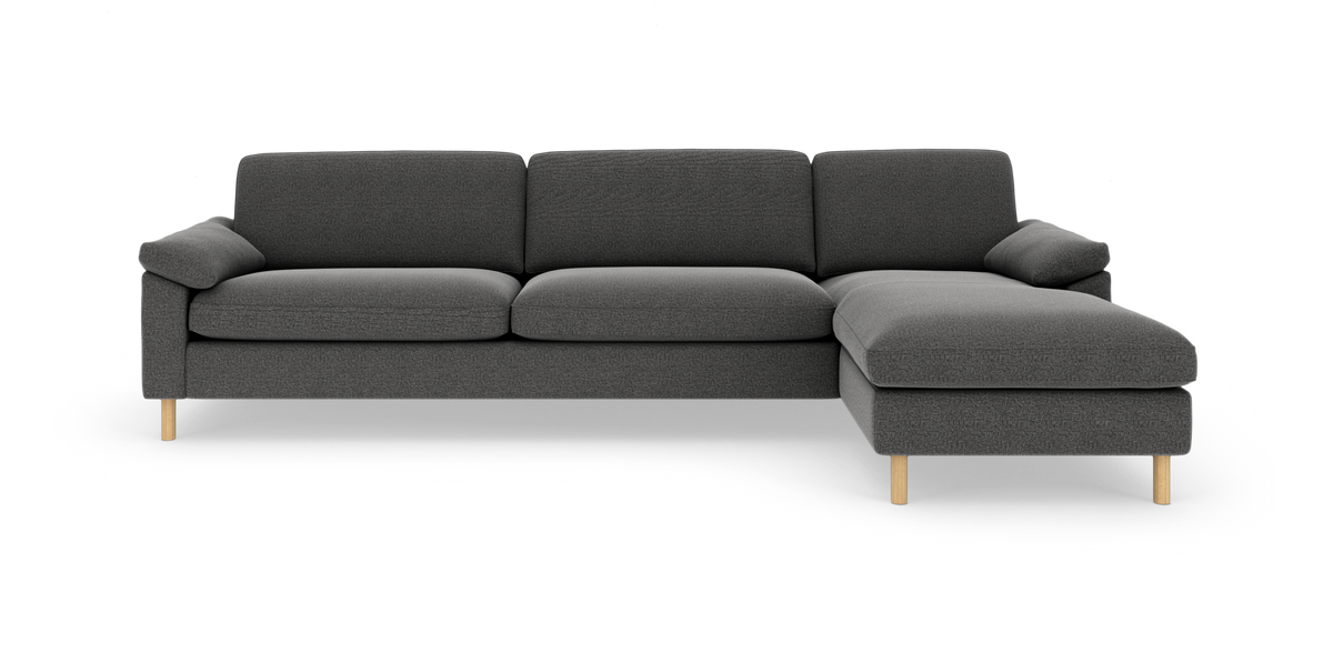 Mørkegrå modulsofa med chaiselong til højre og lyse træben, frilagt på hvid baggrund.