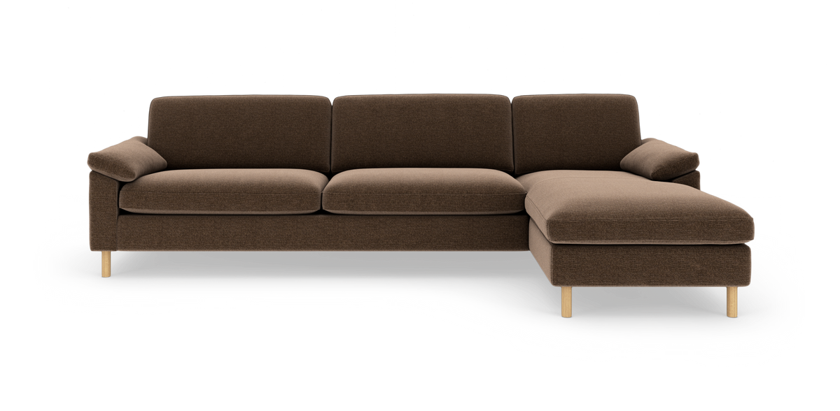 Brun modulsofa med chaiselong til højre og lyse træben, fotograferet frontalt på hvid baggrund.