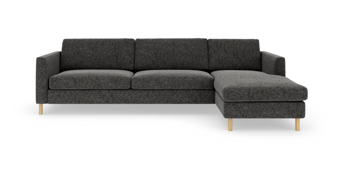 Mørkegrå hjørnesofa med højre chaiselong og lyse træben, frilagt på hvid baggrund.
