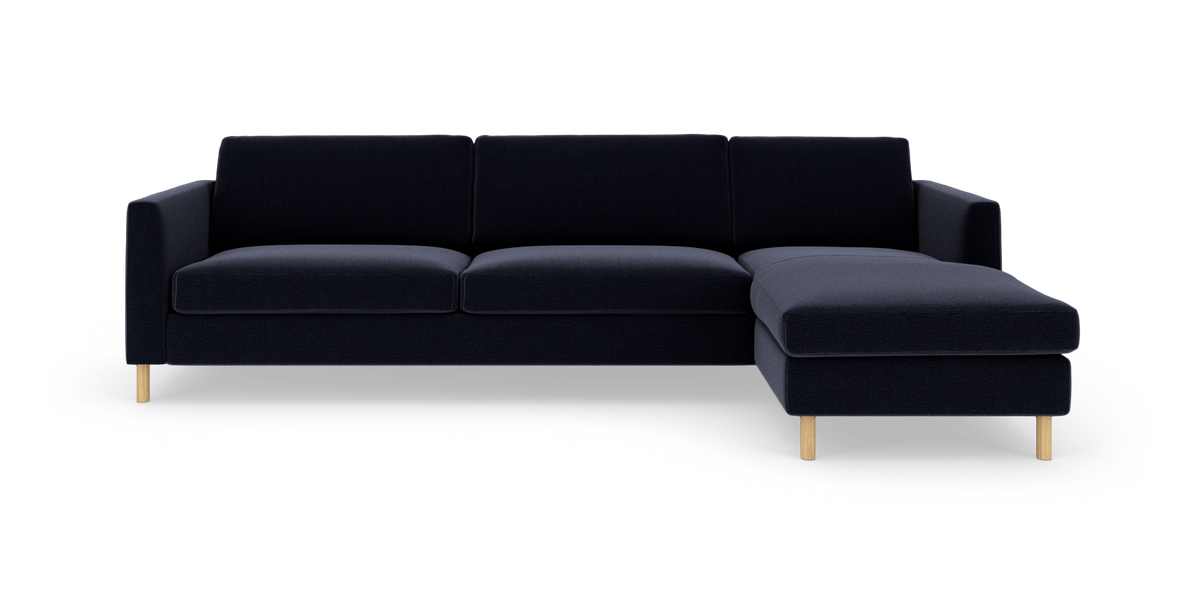 Mørkeblå hjørnesofa med højre chaiselong og slanke runde træben.