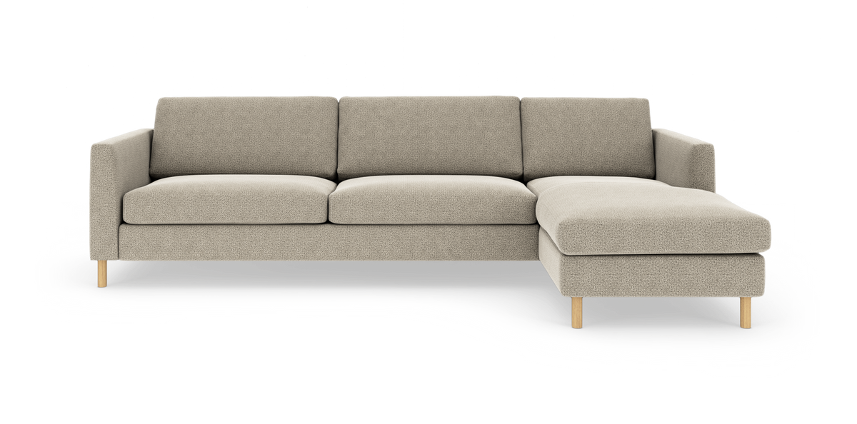Beige modulsofa med chaiselong til højre på hvid baggrund.