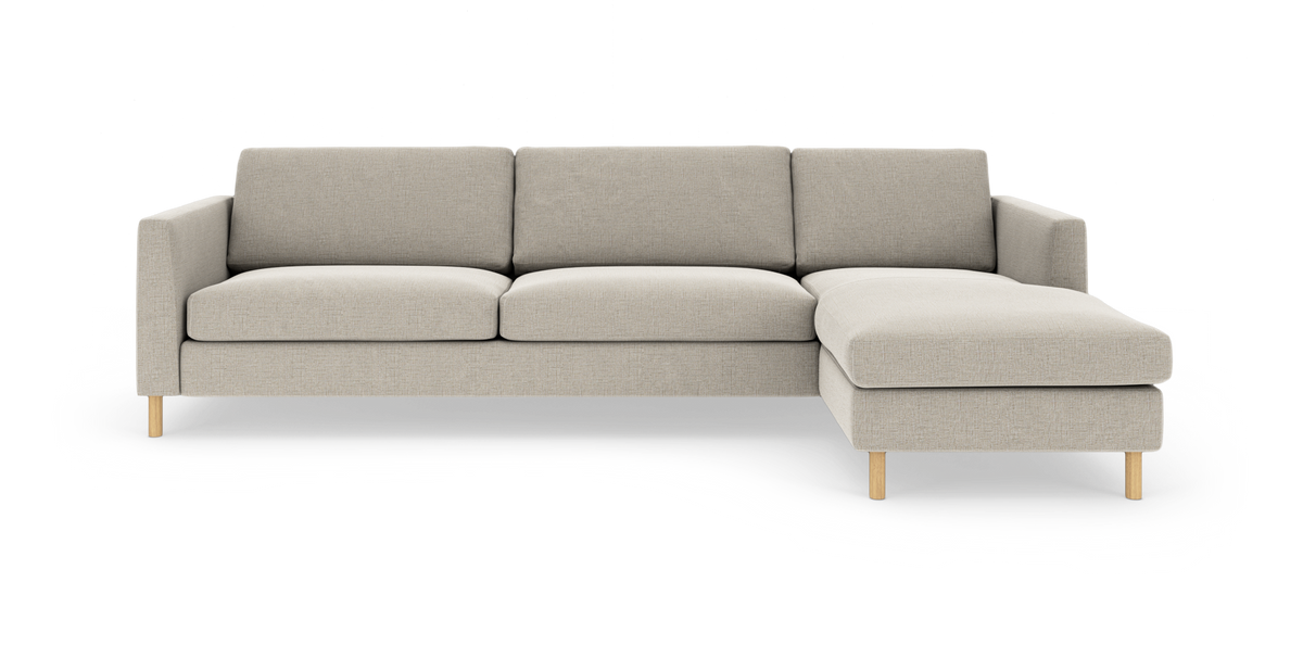Beige L-formet 3-personers sofa med højre chaiselong og træben, frilagt mod hvid baggrund.
