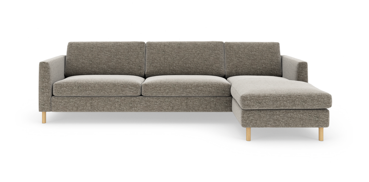 Grå hjørnesofa med chaiselong til højre på hvid baggrund.