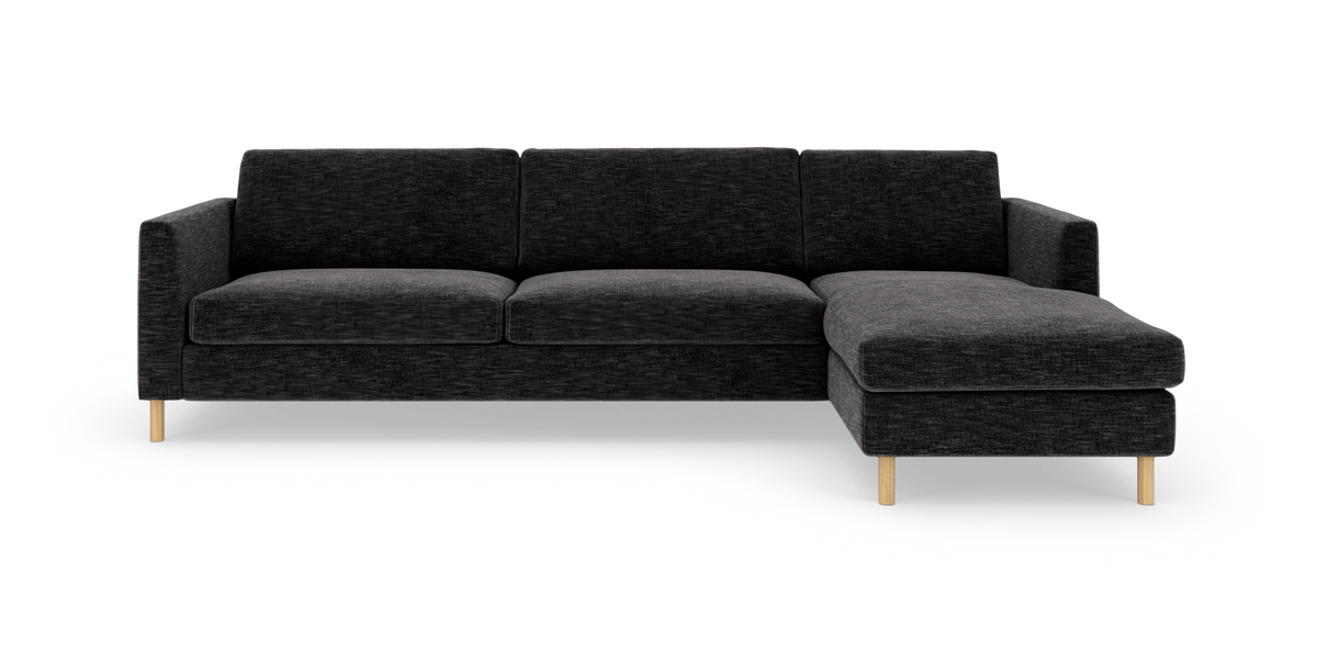 Mørkegrå modulsofa med chaiselong til højre på hvid baggrund.