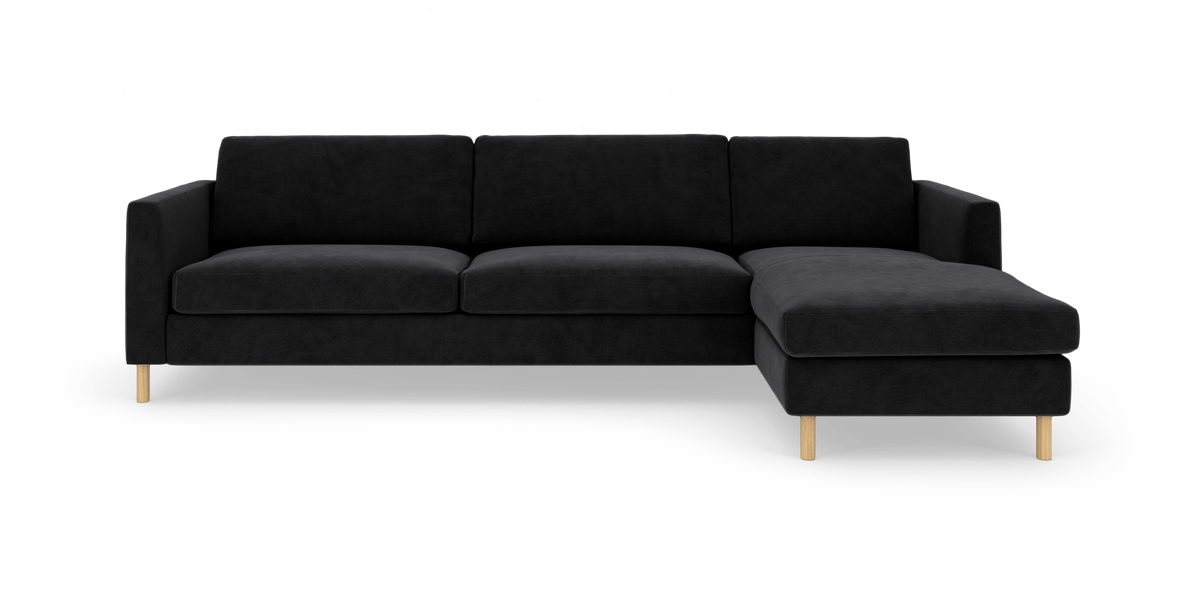 Sort hjørnesofa med chaiselong til højre på hvid studiobaggrund.