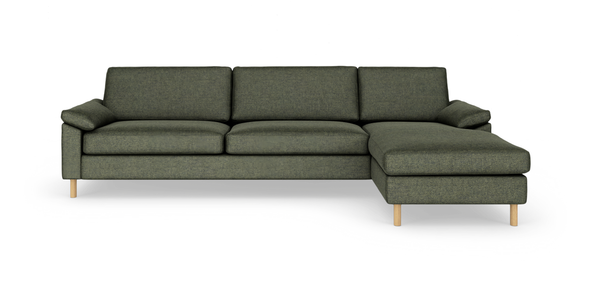 Grøn sofa med højrevendt chaiselong, fritlagt på hvid baggrund.
