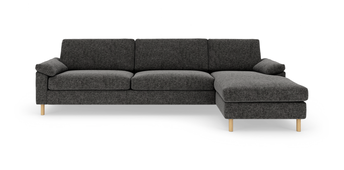 Mørkegrå hjørnesofa med højrevendt chaiselong og lyse træben, frilagt på hvid baggrund.
