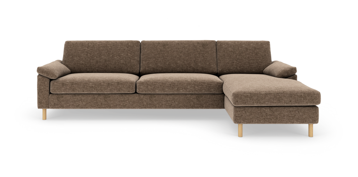 Brun hjørnesofa med chaiselong til højre, træben og bløde puder på hvid baggrund.