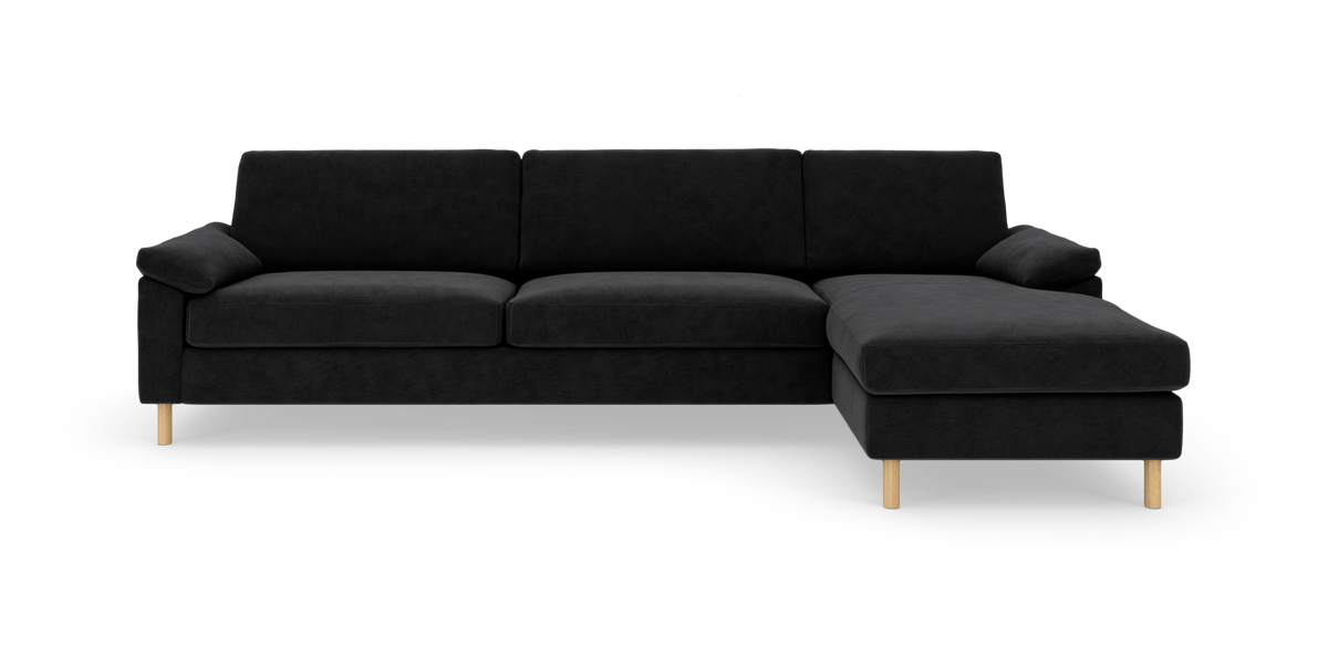 Sort modulsofa med højrevendt chaiselong, træben, frontvisning på hvid baggrund.