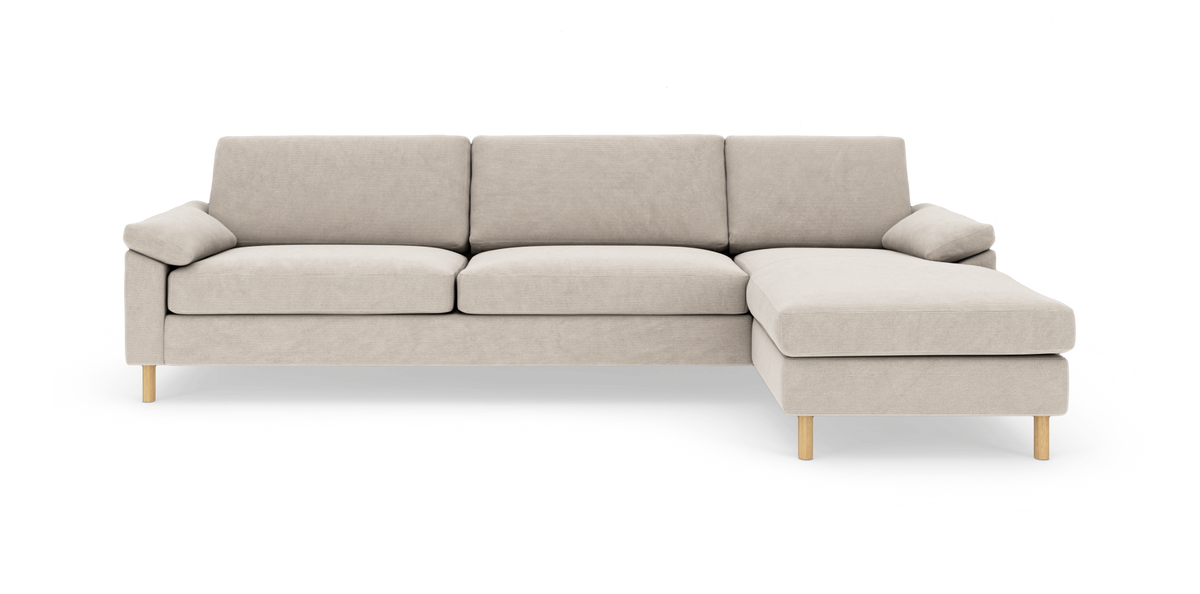 Beige hjørnesofa med chaiselong til højre på træben, fritlagt mod hvid baggrund.