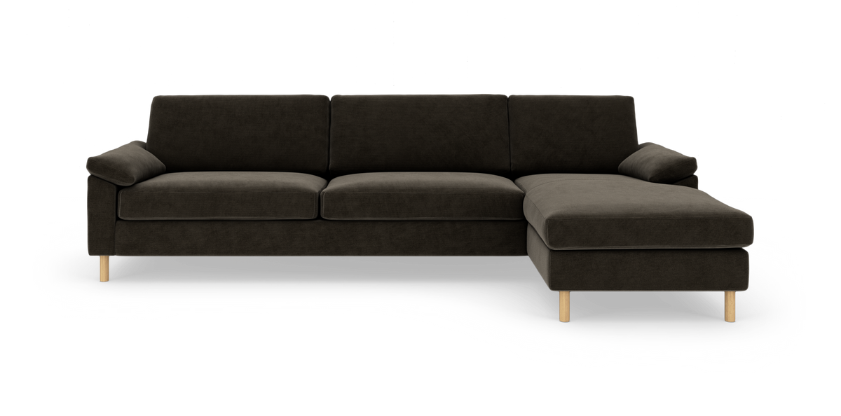 Mørkebrun hjørnesofa med chaiselong til højre og træben, fritlagt på hvid baggrund.