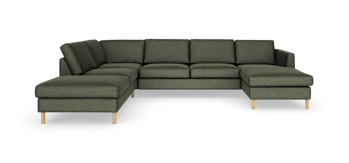 Modulær hjørnesofa i mørkegrønt stof med chaiselonger i begge ender og lyse træben på hvid baggrund.