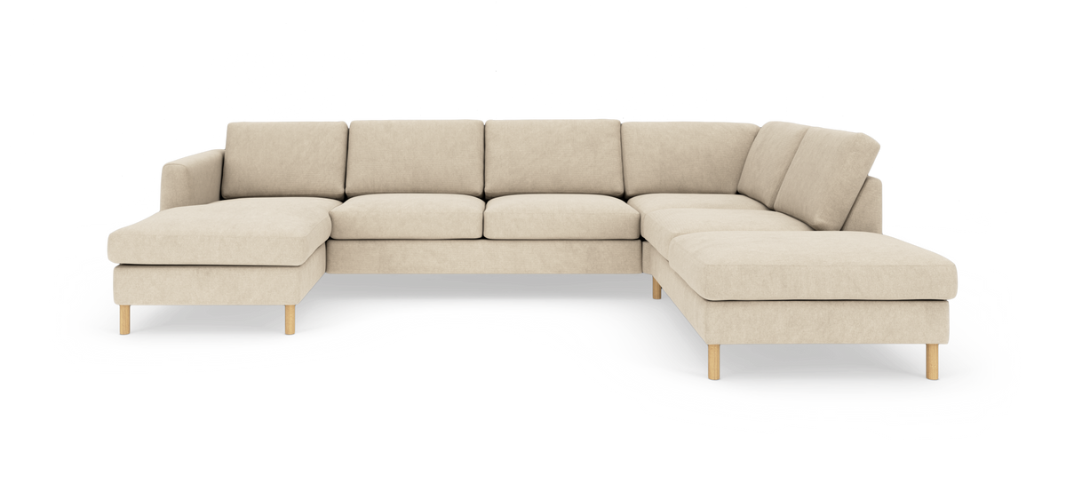 Beige L-formet modulsofa med chaiselong i begge ender og træben, fritlagt på hvid baggrund.