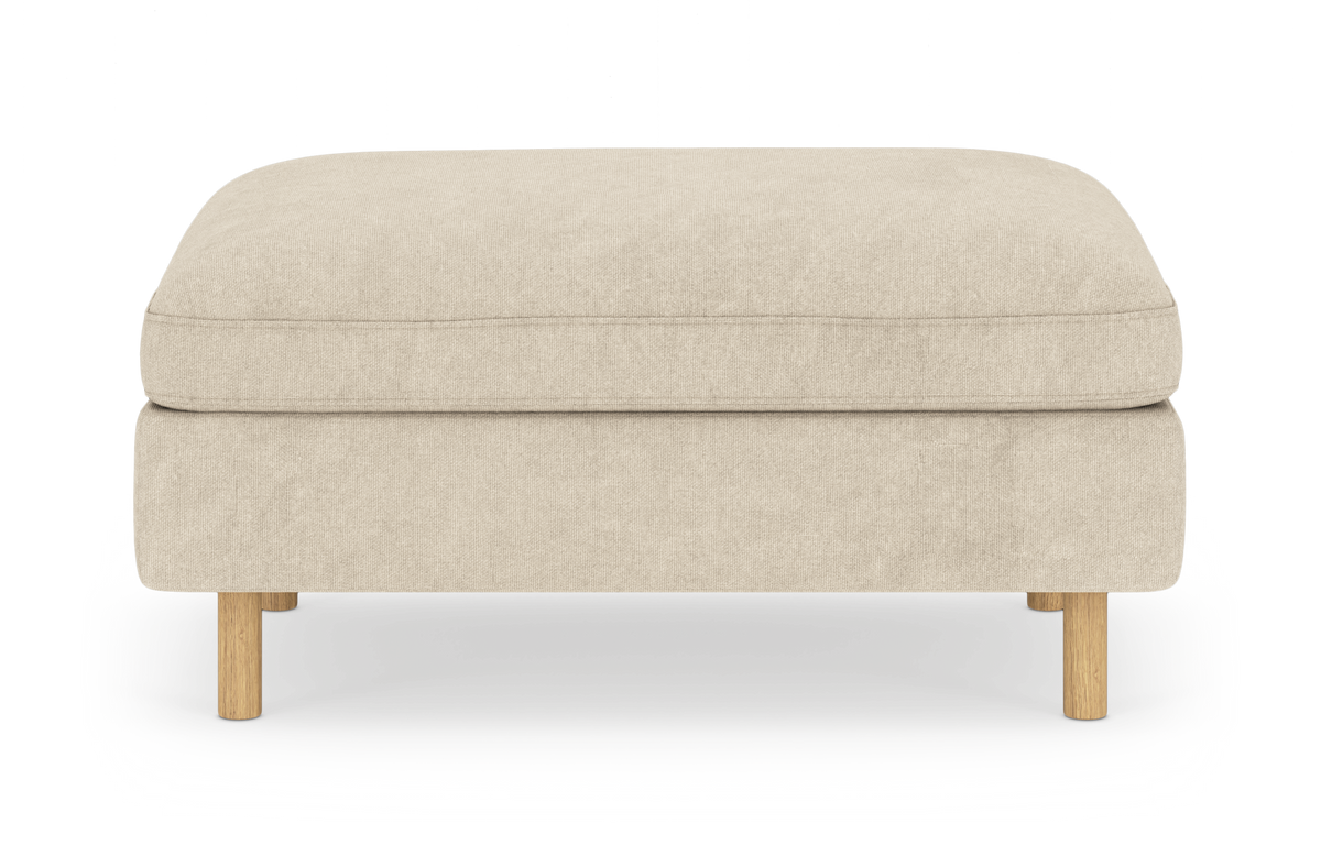Beige puf/ottoman med runde træben, frontvisning på hvid studiobaggrund.