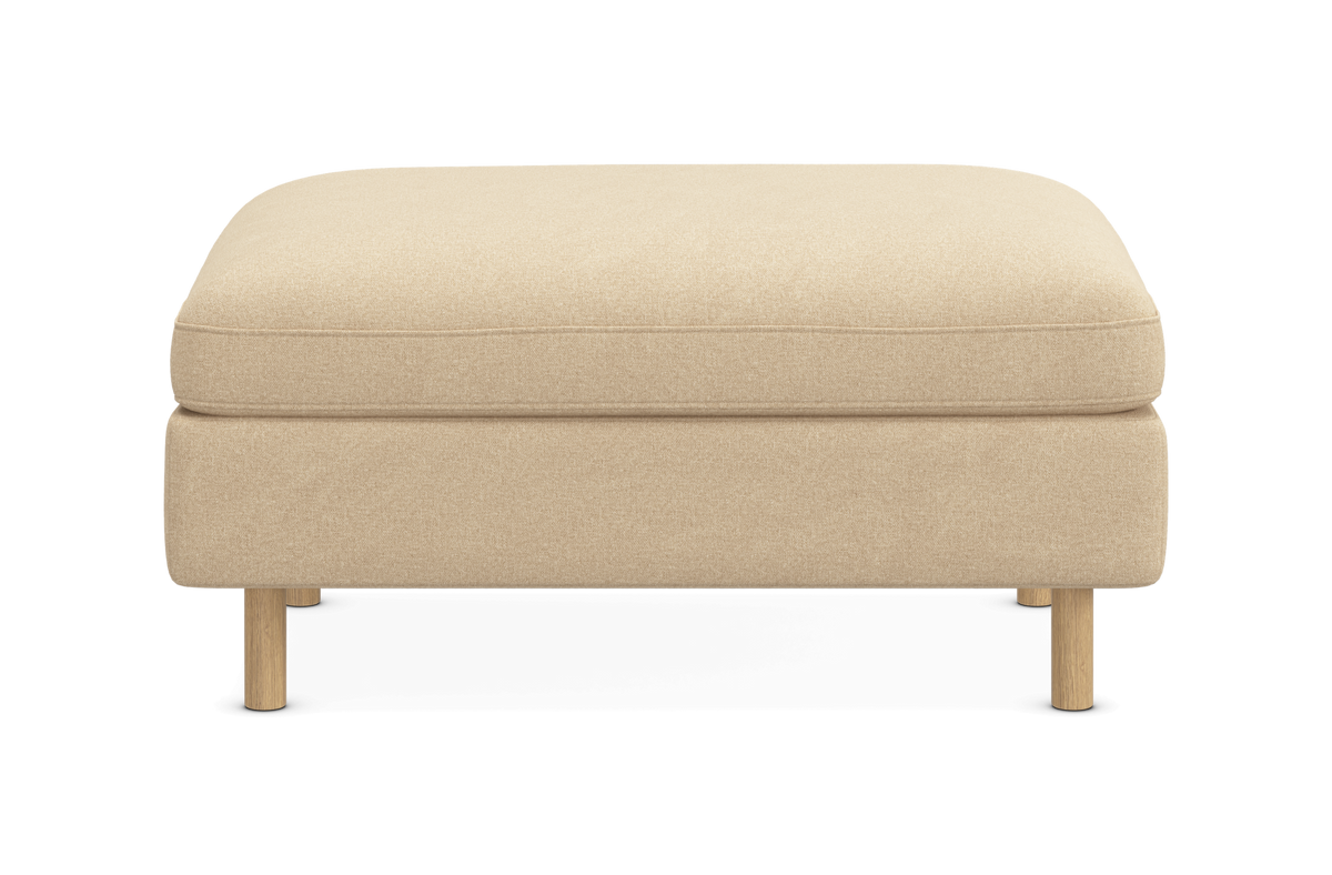 Beige polstret fodskammel med træben set forfra på hvid baggrund.