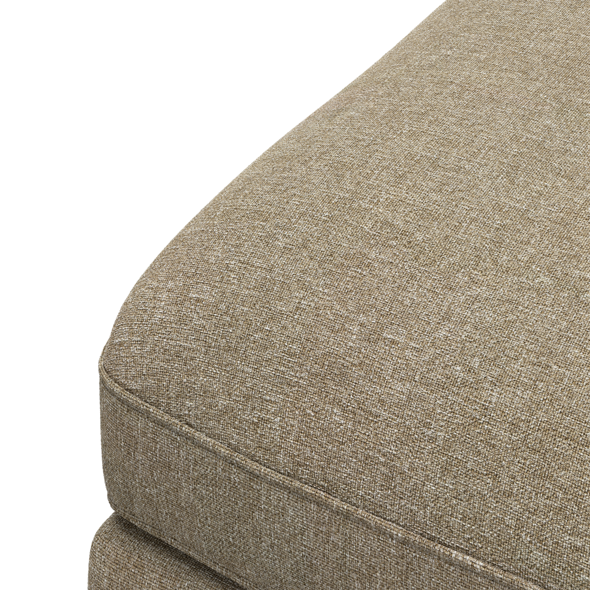Nærbillede af hjørnet på en beige stofsoffapude med piping mod sort baggrund.