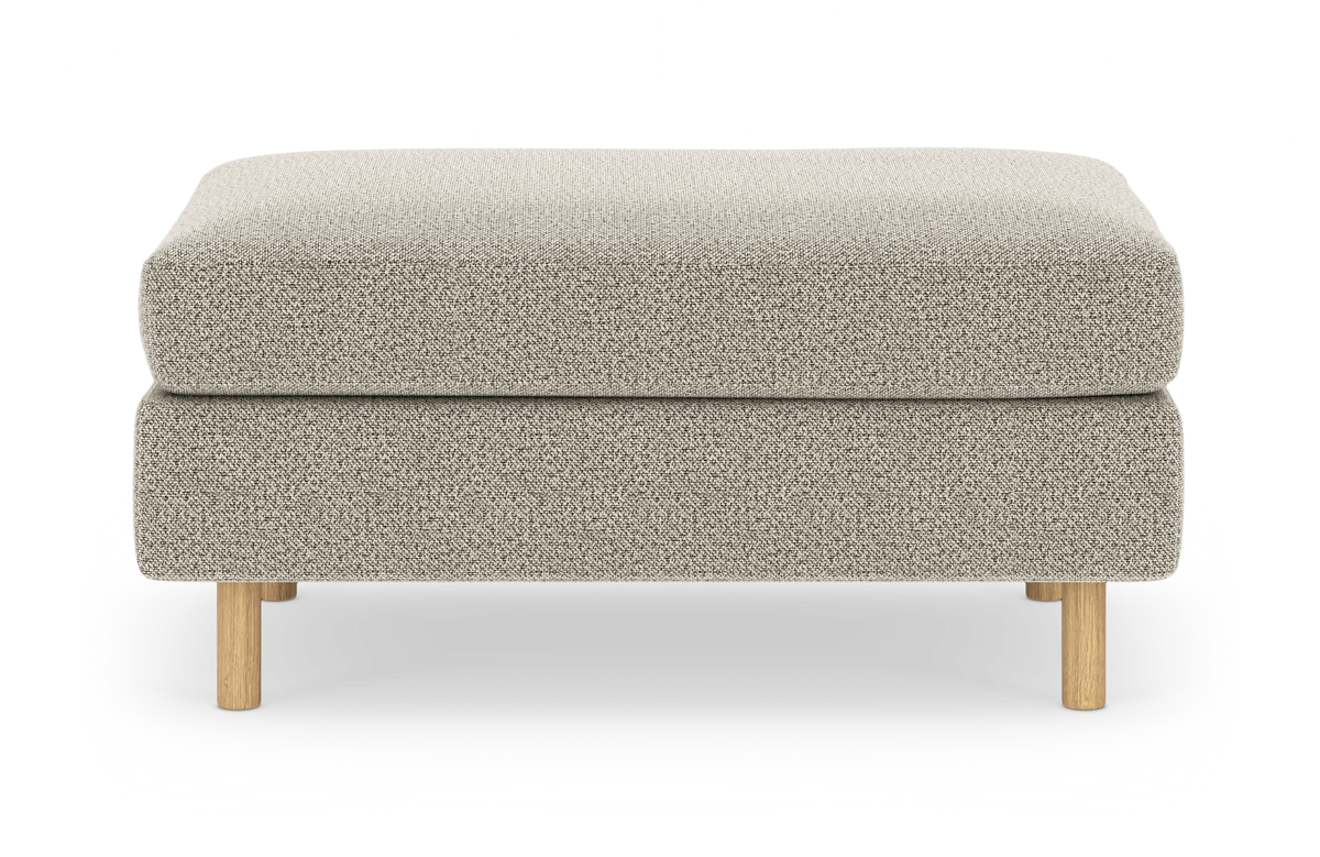 Beige fodskammel/ottoman i tekstil med lyse træben, frilagt produktfoto set forfra.