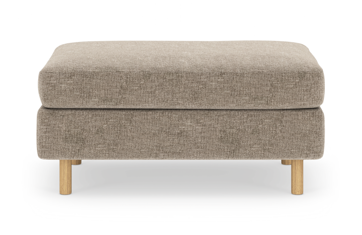 Beige stofbetrukket ottoman/fodskammel med lyse træben, fotograferet forfra i studieopsætning.