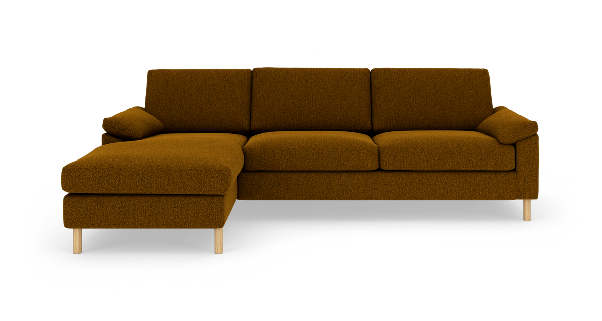 Brun hjørnesofa med chaiselong til venstre, bløde sædehynder og træben, fritlagt på hvid baggrund.