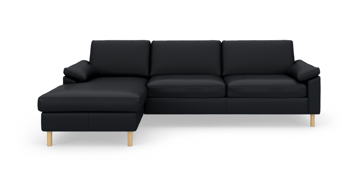 Sort hjørnesofa med venstre chaiselong, tre sæder og lyse træben på hvid studiobaggrund.