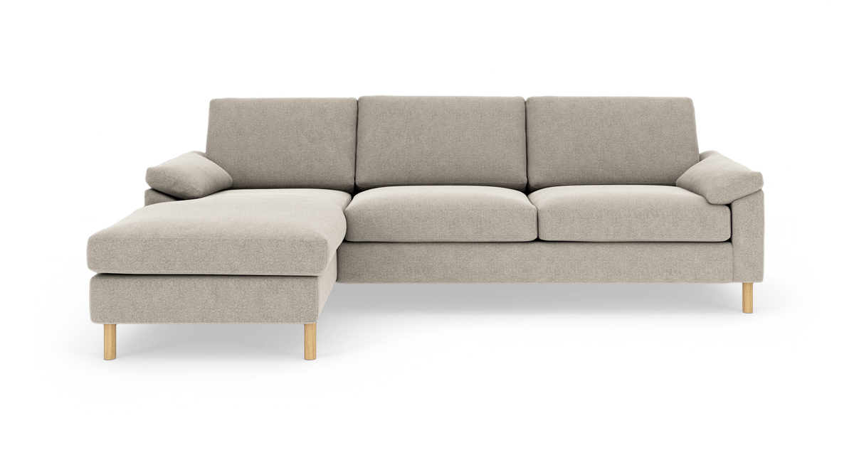 Lys beige modulsofa med venstrevendt chaiselong og lyse træben, fritlagt på hvid baggrund.