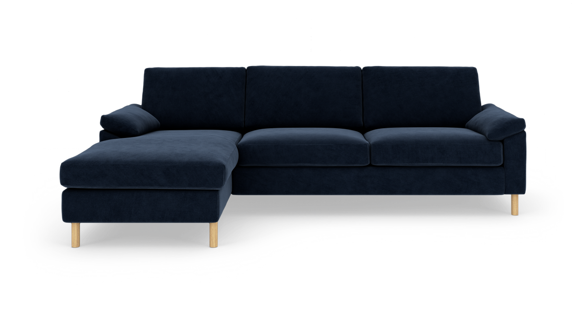 Mørkeblå hjørnesofa med venstrevendt chaiselong og lyse træben, frilagt på hvid baggrund.