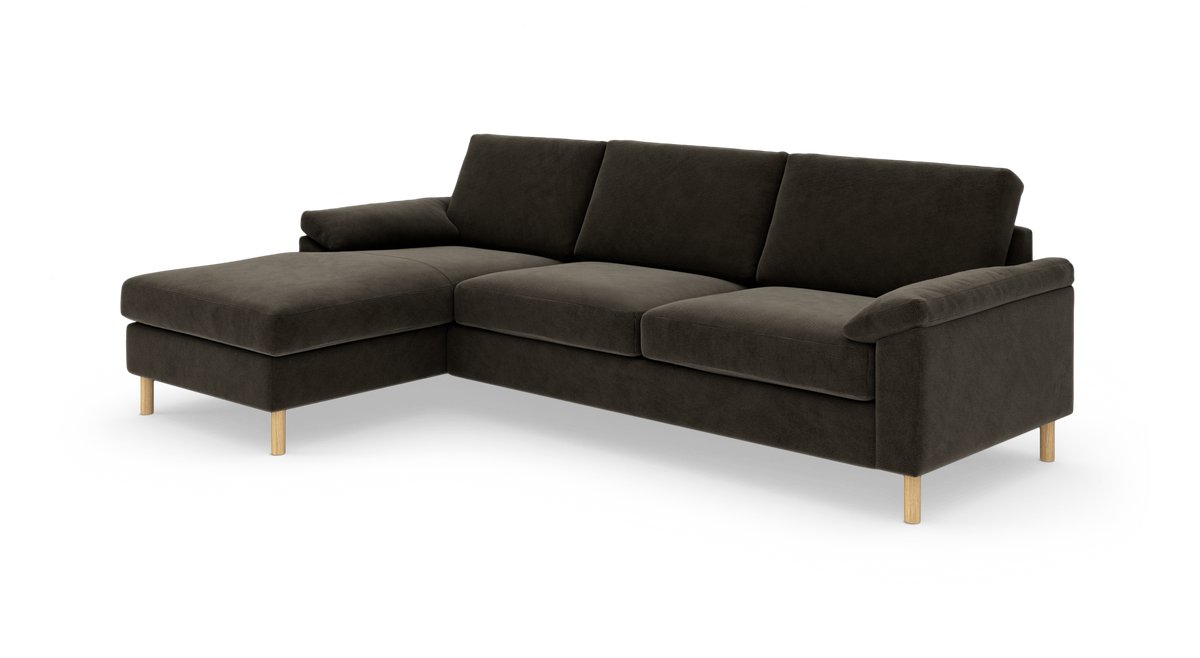 Mørkebrun L‑sofa med venstre chaiselong og lyse træben, studiefoto i vinkel.