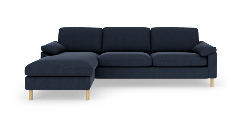 Mørkeblå hjørnesofa med venstrevendt chaiselong og lyse træben, fritstående på hvid baggrund._ps