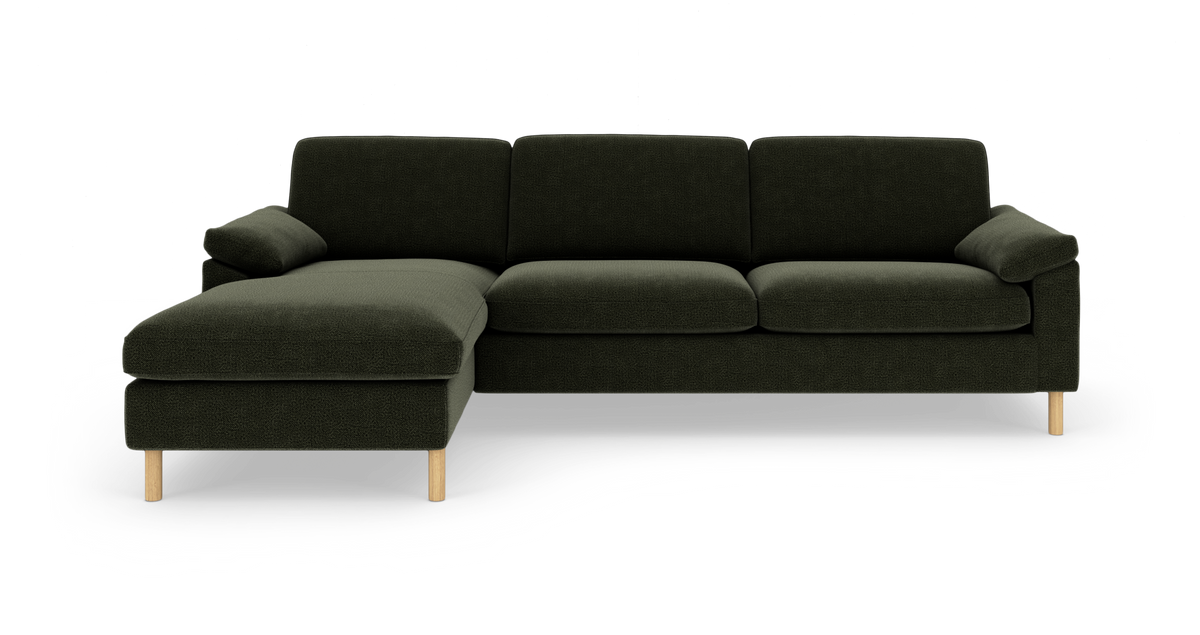 Mørkegrøn modulsofa med venstrevendt chaiselong og lyse træben, frilagt på hvid baggrund.