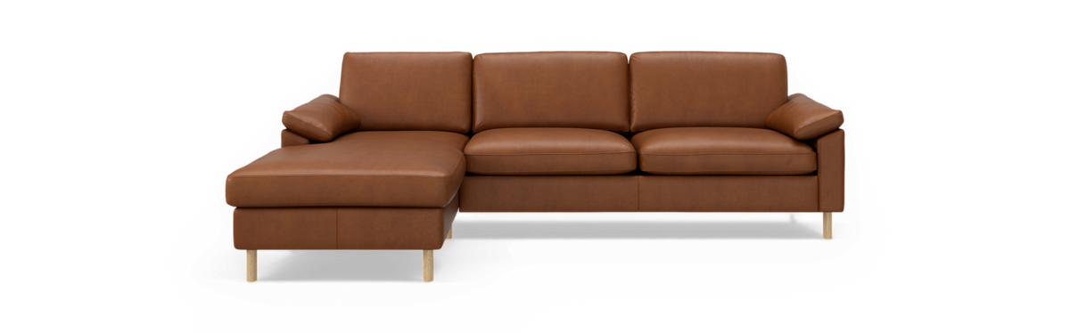 Brun venstrevendt hjørnesofa i læder med chaiselong og lyse træben mod sort baggrund.