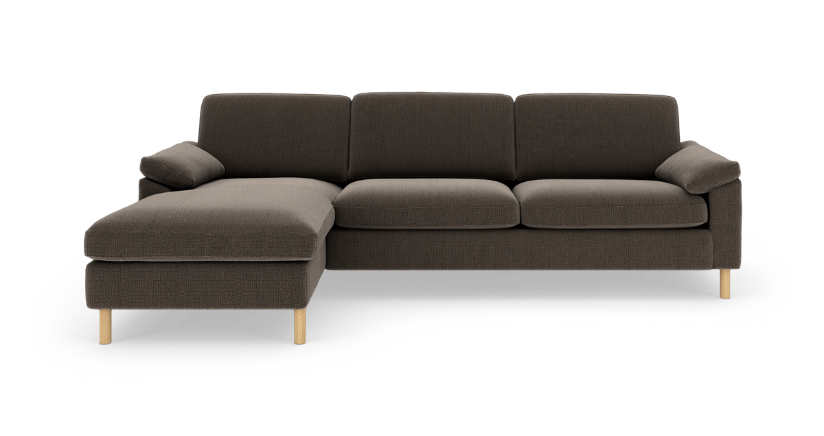 Mørkebrun stofsofa med venstre chaiselong og lyse træben, frontvisning mod hvid studiebaggrund.