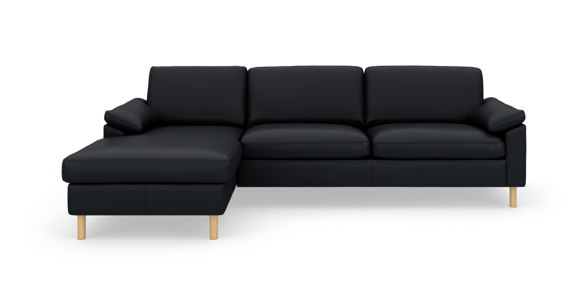 Sort hjørnesofa med venstrevendt chaiselong og lyse træben, set forfra på hvid baggrund.