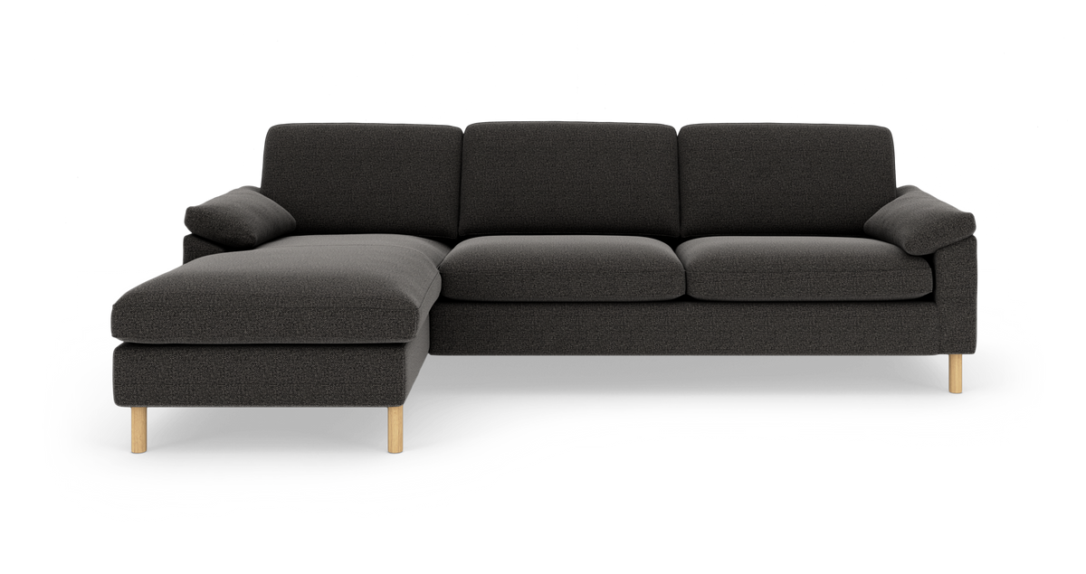 Mørkegrå modulsofa med venstrevendt chaiselong og lyse træben, set forfra.